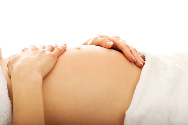 Pregnant woman massagin her belly stock photo