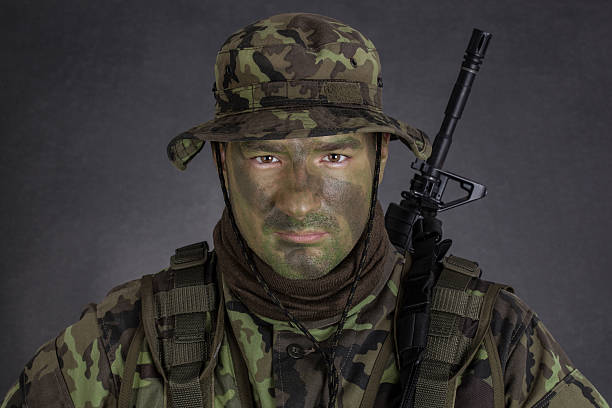 istock Young soldier with jungle camouflage paint. 496835273
