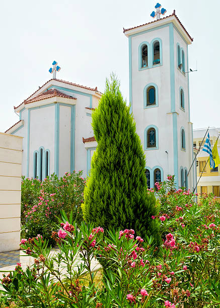 Itea, Greece - July 30, 2006: Just viewing from Itea Church. greek orthodox Church in the garden with Greek Flag. 