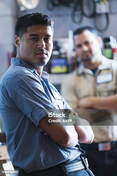 Hispanic Man Working In Garage Stock Photo - Download Image Now - Auto Mechanic, Sadness, Mechanic