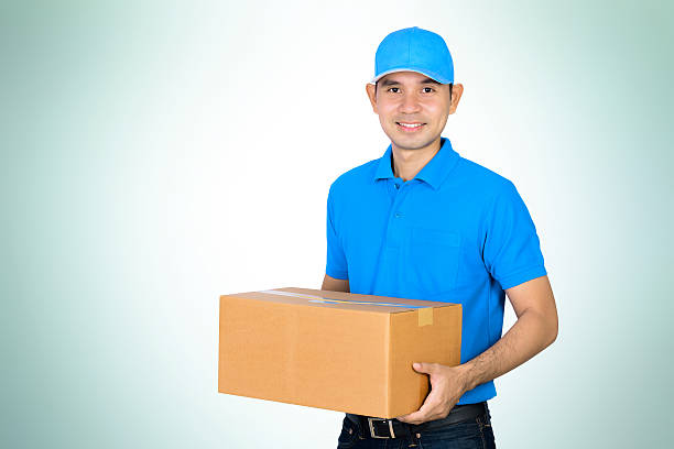 istock Deliveryman carrying a cardboard parcel box 496847610