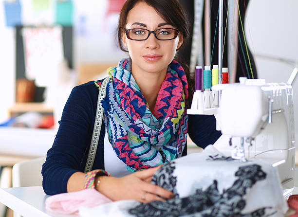 istock Young woman sewing while sitting at her working place 496847994