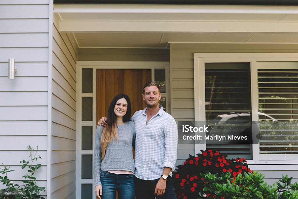 happy couple with new home Happy couple standing in front of their home. Australia Stock Photo