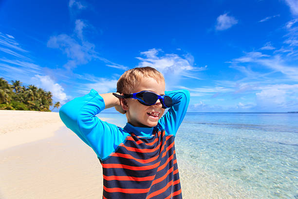 istock happy boy in swimming goggles on beach 496848614