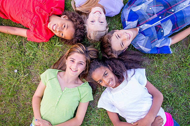 istock Children Lying Together in the Grass 496850324