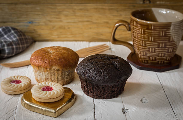 istock Cupcakes with cup coffee  on a wooden table background 496850956