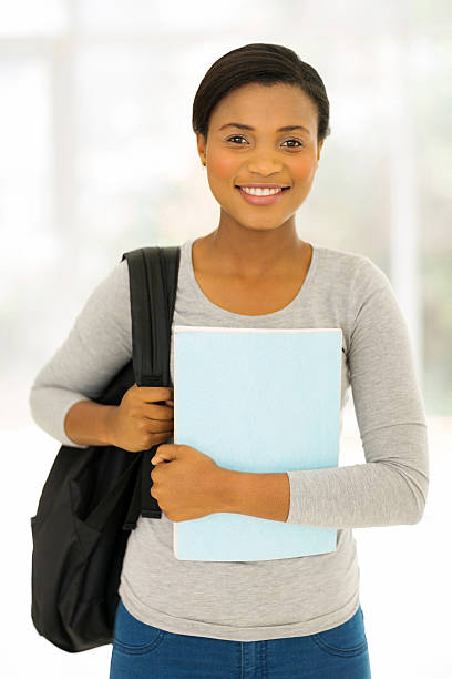istock female afro american student holding a book 496851100