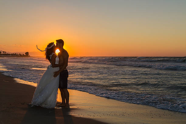 istock Newly wed young couple on a hazy beach at dusk 496851504