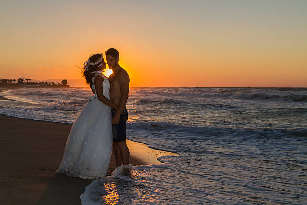 istock Newly wed young couple on a hazy beach at dusk 496851594