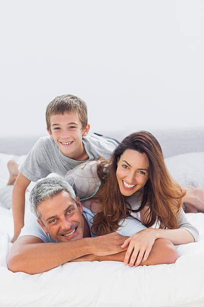 istock Parents with their son lying on bed 496852083