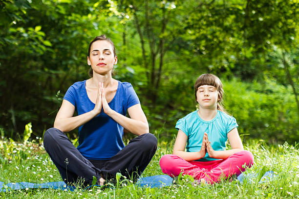 istock Mother and daughter meditating 496852473