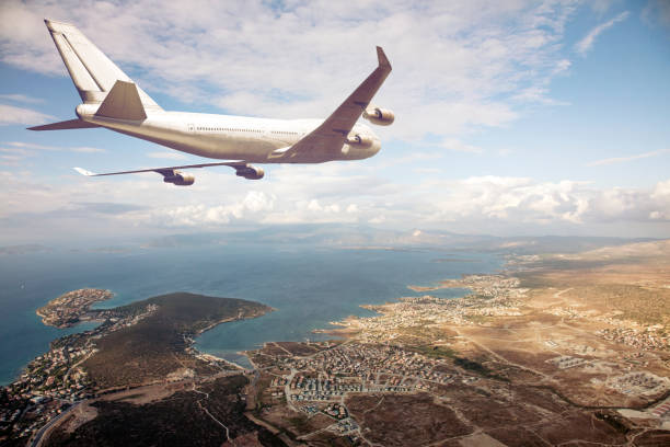 istock airplane flying above a seaside city 496853212