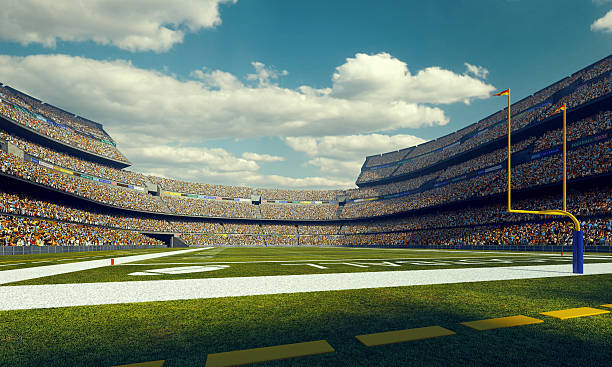 Sunny american football stadium A wide angle panoramic image of a outdoor american football stadium full of spectators under blue sky. The image has depth of field with the focus on the foreground part of the pitch. The view from back line of the field. american football field photos stock pictures, royalty-free photos & images
