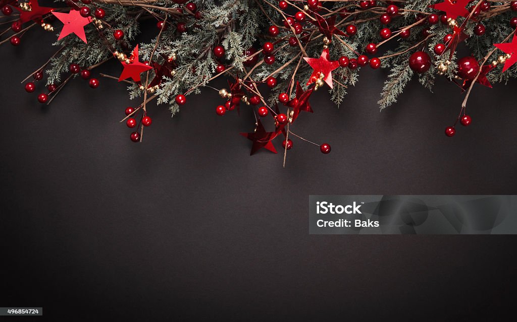 Christmas decoration with fir branches Christmas decoration with fir branches and red berries on a dark background 2015 Stock Photo