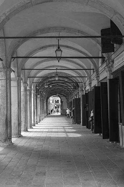 venice, italy - May 16, 2014: People are shopping at tourist shops under old corridor with arches at venice italy