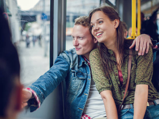 istock Happy young couple riding in bus and looking through window. 496856386