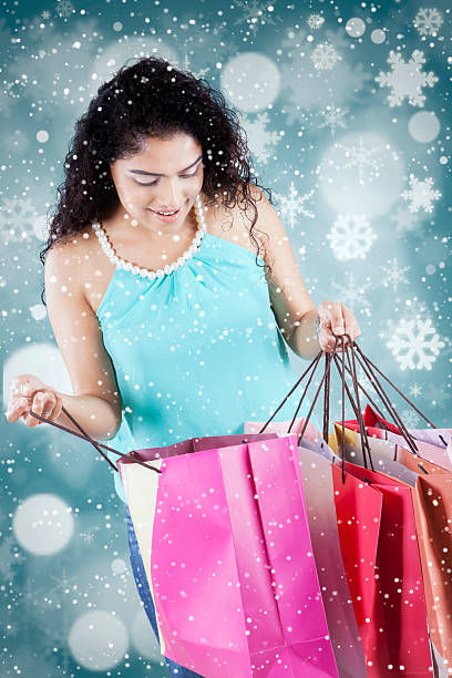 istock Woman opens shopping bags with winter background 496857192
