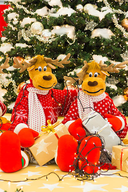 istock Reindeer preparing Christmas tree lights and presents 496857680
