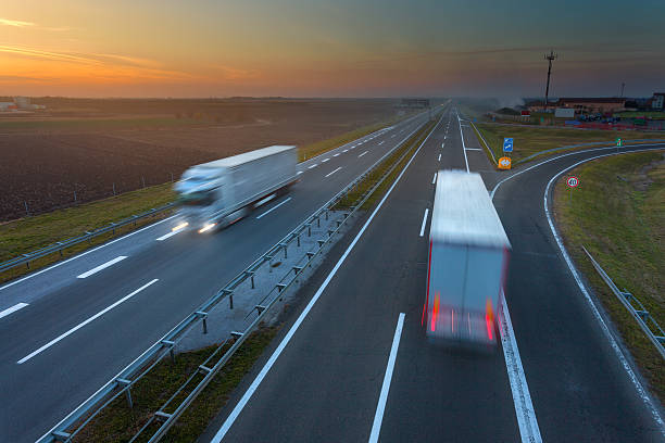 istock Driving trucks in motion blur on the highway at sunset 496859764