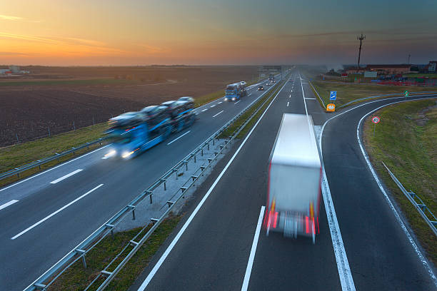 istock Many trucks in motion blur on the highway at sunset 496859962