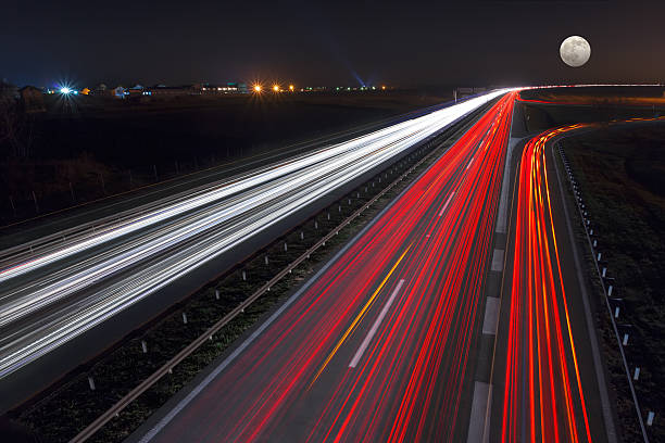 istock Speed driving on highway at night of full moon 496860320