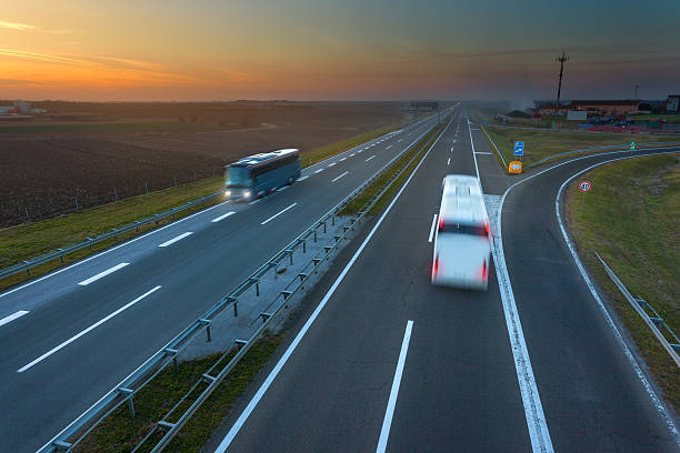 istock Two buses in motion blur on the highway at sunset 496860602
