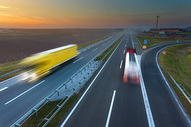 istock Two trucks in motion blur on the highway at sunset 496860822