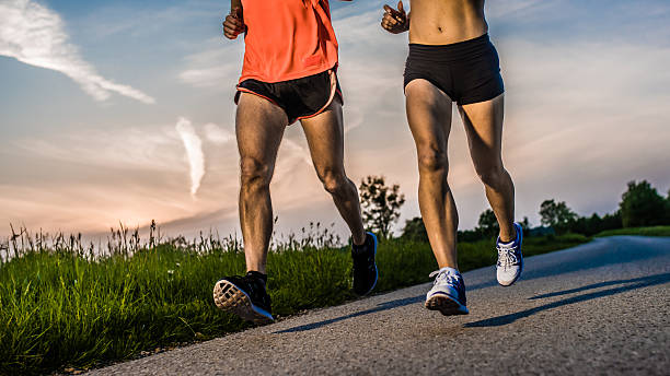 istock Man and woman jogging in park 496873840