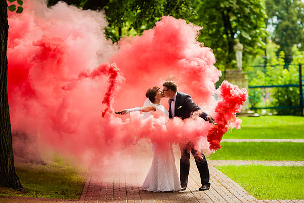 noiva e noivo com um vermelho brilhante de fumaça - wet dress rain clothing - fotografias e filmes do acervo