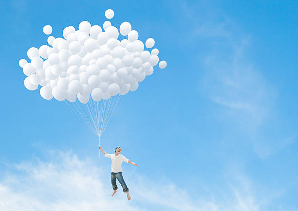 istock Man lifted into sky by huge bunch of white balloons 496876152