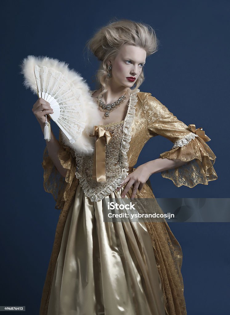 レトロなバロックファッション女性ゴールドのドレスを着ている。 ファンを押します。 - バロック様式のロイヤリティフリーストックフォト