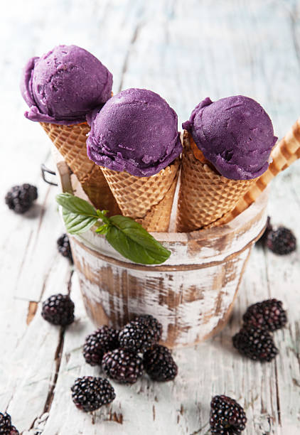 istock Blueberry fresh ice cream scoops in cones on wood 496876589