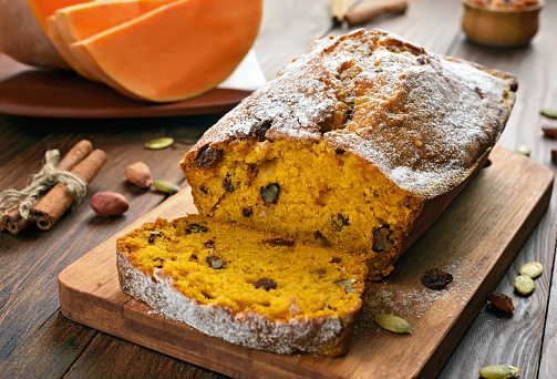 Pumpkin bread and ingredients on wooden table