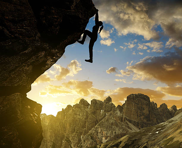 istock girl climbing on rock at sunset in Sexten Dolomites 496876884
