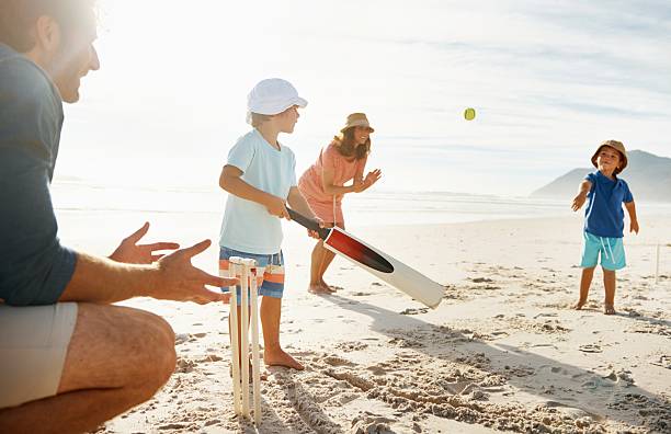 istock Family playing cricket at a beach in the sun 496877921