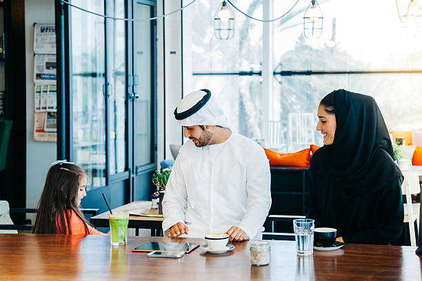 istock Young Arab family enjoying with tablet pc at cafe 496880056