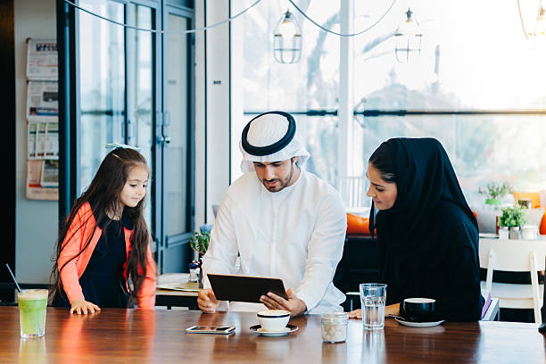 istock Young Arab family enjoying with tablet pc at cafe 496880142