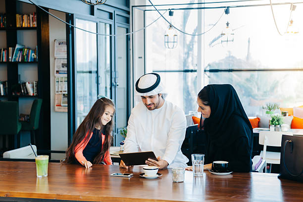 istock Young Arab family enjoying with tablet pc at cafe 496880224