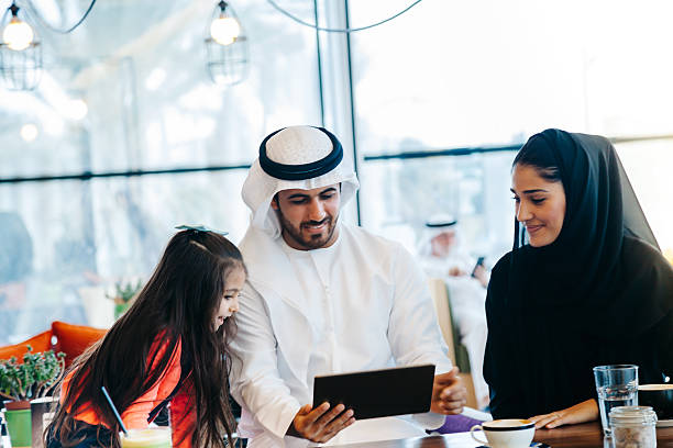 istock Young Arab family enjoying with tablet pc at cafe 496880422
