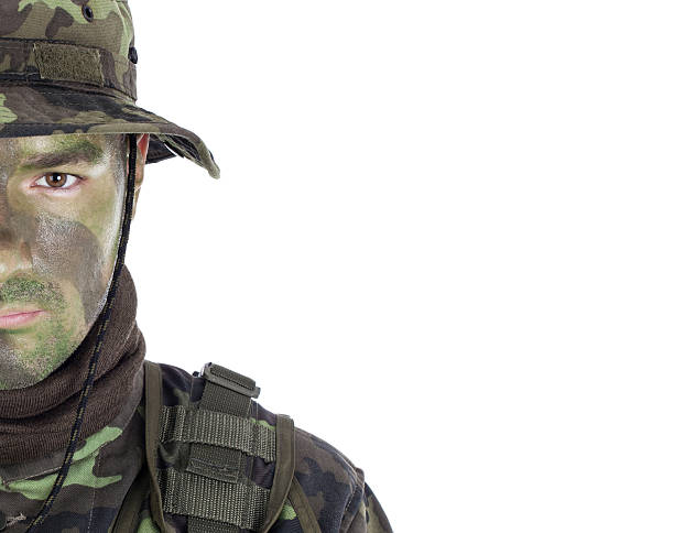 Young soldier with jungle camouflage paint. Isolated on white background