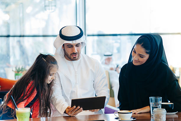 istock Young Arab family enjoying with tablet pc at cafe 496880474