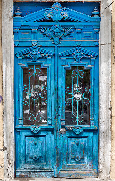 istock Old wooden door covered with cracks, worn paint. 496880605