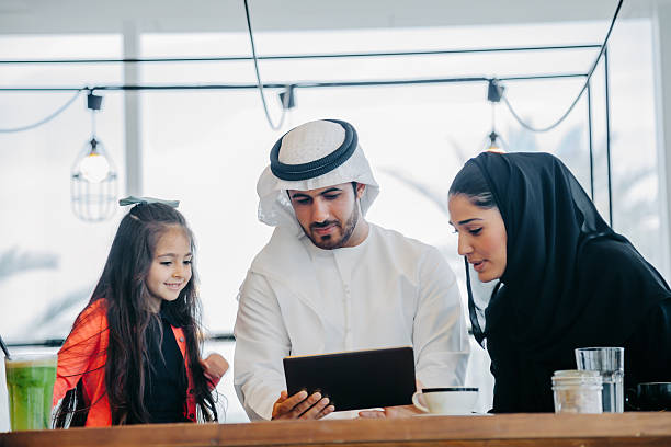 istock Young Arab family enjoying with tablet pc at cafe 496881034