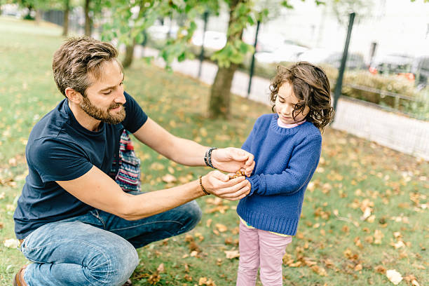 father and daughter picking up hazelnuts