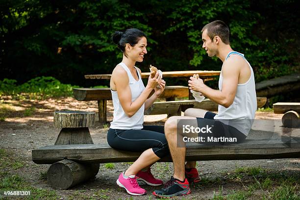 Pareja Comiendo Juntosdespués De Trotar Foto de stock y más banco de imágenes de Adulto - Adulto, Adulto joven, Alegre