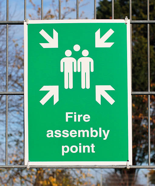 istock Green safety sign for fire assembly point outdoors 496882766