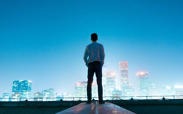 istock Businessman looking at cityscape at night 496885796
