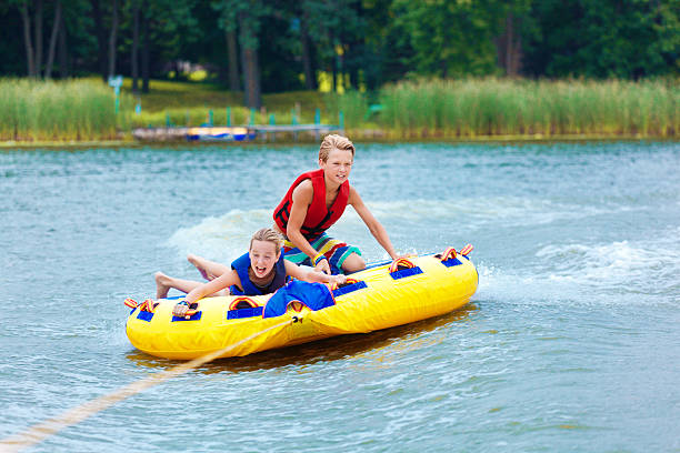 мальчик и девочка дети трубки на миннесота озеро в лето - water sport family inner tube sport стоковые фото и изображения