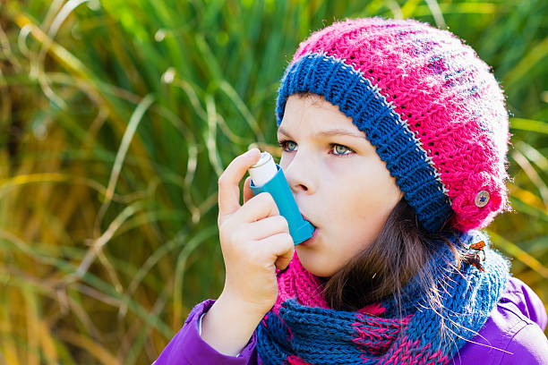 istock Girl Using Asthma Inhaler on an autumn day 496886730