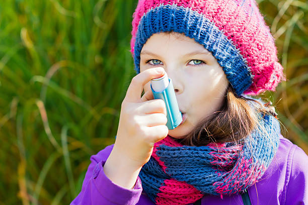 istock Girl Using Asthma Inhaler on an autumn day 496886778